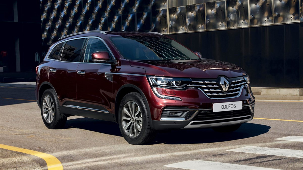 A wine-colored New Renault KOLEOS standing in front corner view with sunlight falling in