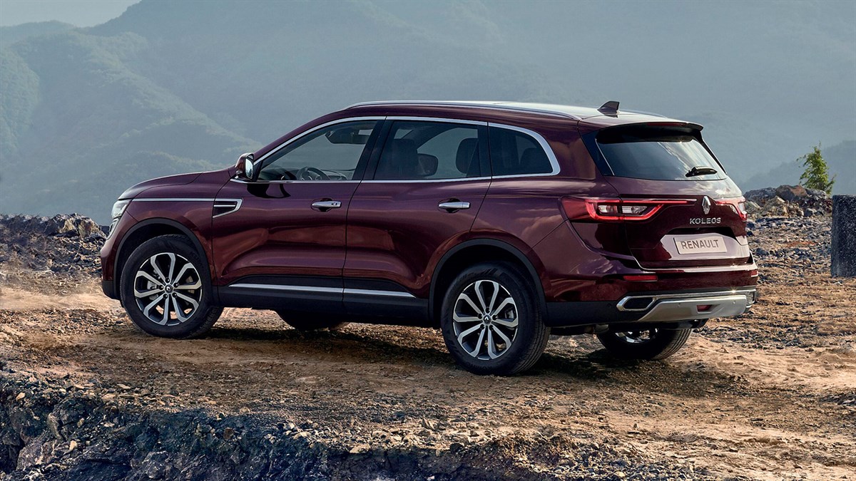 A side view of the wine-colored New Renault KOLEOS running in the hill