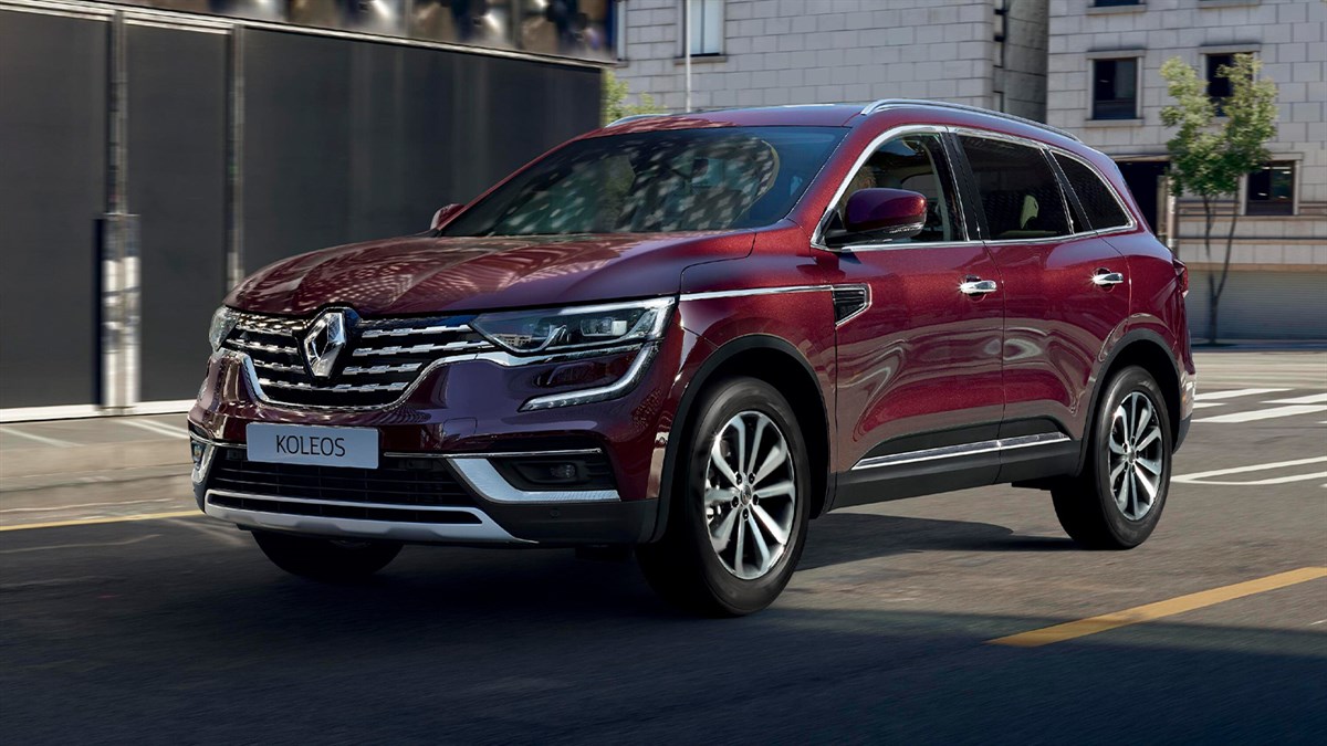 A side view of the wine-colored New Renault KOLEOS running towards the shade of a building