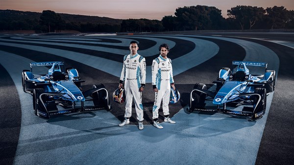 Two drivers standing in a Sporty look near each of their FORMULA E cars