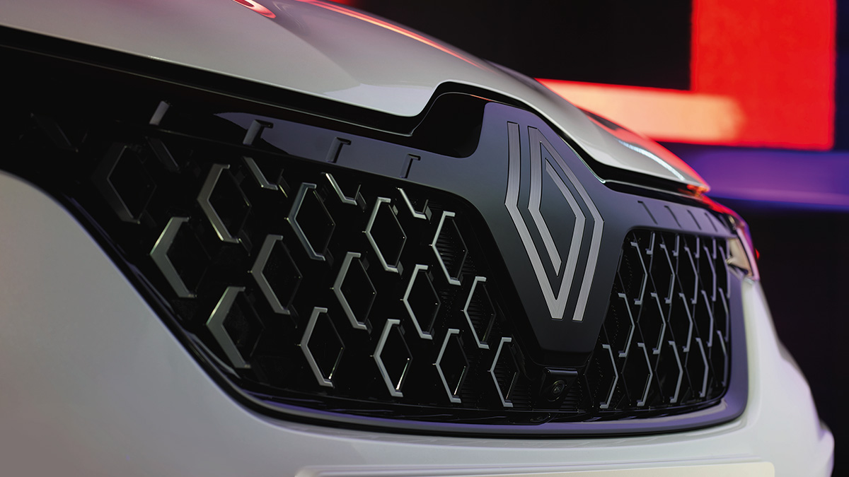 A front corner view of the wine-colored New Renault KOLEOS running slantier in the rocky hill