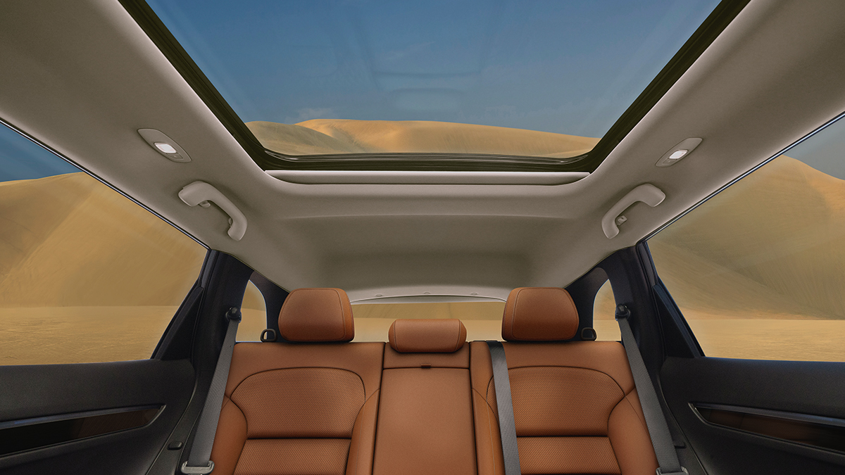 A side view of the wine-colored New Renault KOLEOS running towards the shade of a building